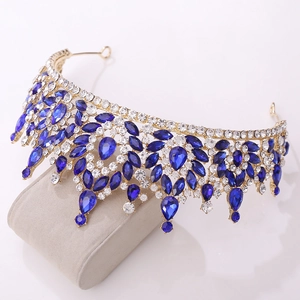 Close-up of golden bridal crown with deep blue crystals and shimmering rhinestones