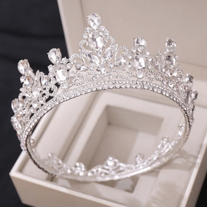 Close-up detail of silver bridal crown with white crystals in a beige jewelry box