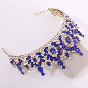 Detailed close-up of Baroque gold crown with blue crystals and white rhinestones