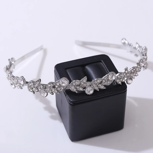 Elegante cerchietto foglia d'argento con strass luccicanti su supporto per gioielli