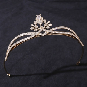 Close-up of golden bridal crown with sparkling zircons and water-drop diamond on black background