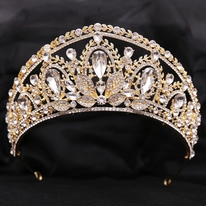 Détail d'une couronne de mariée dorée avec un grand cristal en poire et des motifs de vigne