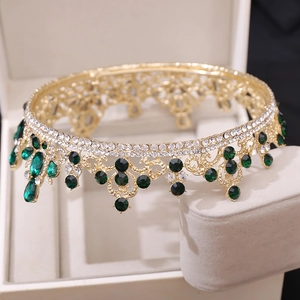 Close-up of luxury Baroque gold bridal crown with vintage green crystals and rhinestones
