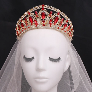 Détail d'une couronne de mariée dorée avec pierres rouges en goutte et diamants