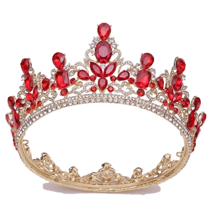 Macro detail of luxury baroque tiara featuring red crystal gemstones and gold alloy finish