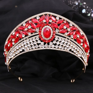 Detailed close-up of a vintage bridal crown with red rhinestones and gold alloy frame