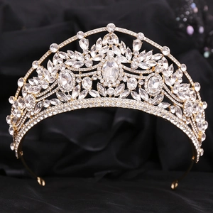 Détail de la couronne de mariée dorée avec cristaux brillants sur fond de soie noire