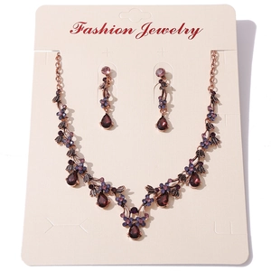 Detail of vintage necklace and teardrop earrings set with deep purple crystal stones