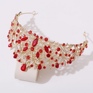 Close-up of golden baroque bridal crown featuring red teardrop crystals and filigree