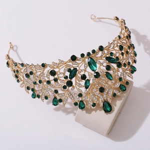 Macro detail of baroque bridal crown with emerald green crystals and golden alloy leaves