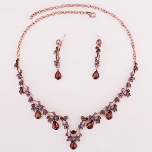 Detailed view of vintage bronze bridal jewelry set with red crystals and purple rhinestones