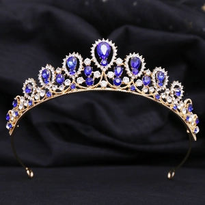 Macro detail of royal gold tiara with deep blue teardrop crystals and white rhinestones
