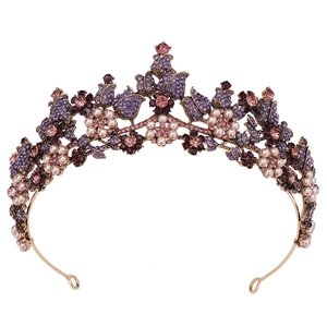 Close-up of vintage bridal crown with purple rhinestones, pink gems and white pearls