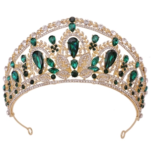 Détail d'une couronne de mariée dorée avec gemmes vert émeraude et strass brillants