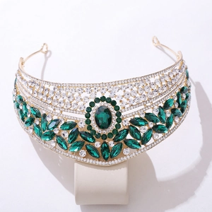 Detail view of gold bridal crown featuring teardrop green gems and white rhinestones