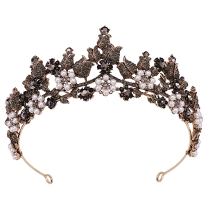 Macro detail of antique gold bridal tiara with black rhinestones and white pearls