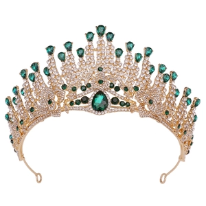 Detailed macro of golden crystal crown with emerald gemstones and sparkling rhinestones