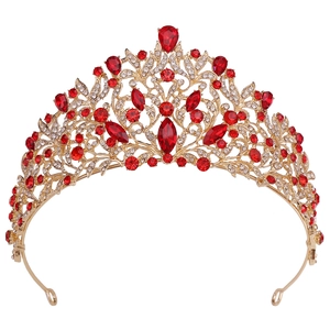 Macro detail of Baroque bridal crown with red crystals and golden alloy floral patterns
