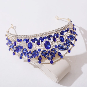 Détails d'une couronne de mariée dorée avec de grands cristaux bleu foncé et strass scintillants