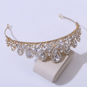 Close-up of elegant gold tiara with sparkling white rhinestones on curved display stand