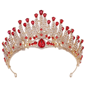 Close-up of golden bridal crown featuring large red teardrop gem and white crystals