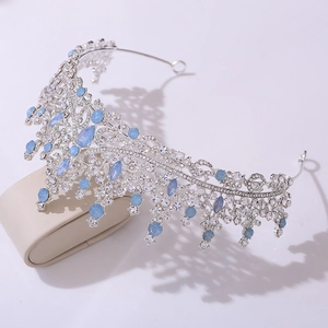 Détail de couronne de mariée argentée avec cristaux bleu clair et dentelle évidée