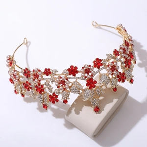 Macro detail of bridal crown with gold metal frame, red rhinestones and white pearls