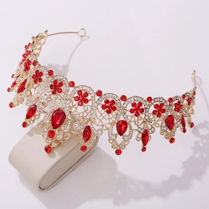 Detailed view of Baroque bridal crown with gold metalwork and deep red gemstones