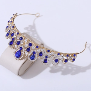 Detail of a golden bridal crown with blue teardrop gemstones and small white crystals