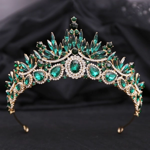Detail of baroque gold crown with deep green gemstones and sparkling zircons