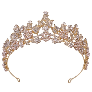 Elegant bridal tiara with golden leaves, pink pearls and crystal flowers on white backdrop