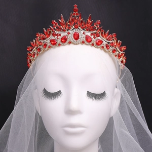 Luxury Baroque bridal crown with red crystals and gold leaves on a mannequin with veil