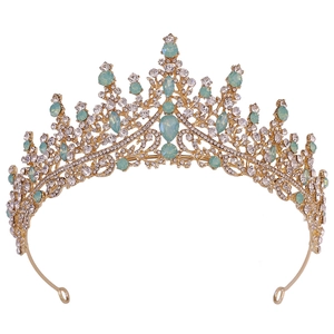 Détail de la couronne de mariée baroque dorée avec gemmes vert menthe et cristaux