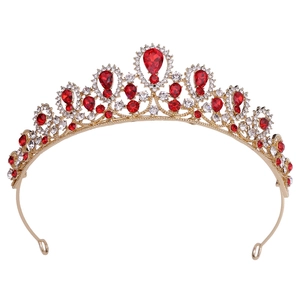 Detailed close-up of golden bridal tiara featuring red teardrop stones and white crystals