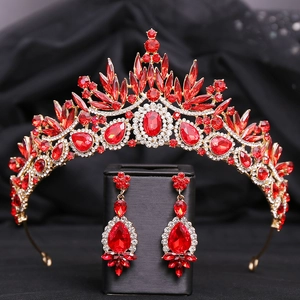 Detail of red crystal baroque bridal tiara and matching earrings on black satin background