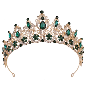 Detailed macro shot of vintage gold bridal crown with emerald gems and crystals