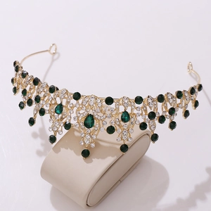 Macro detail of bridal crown featuring emerald green gems and gold filigree metalwork