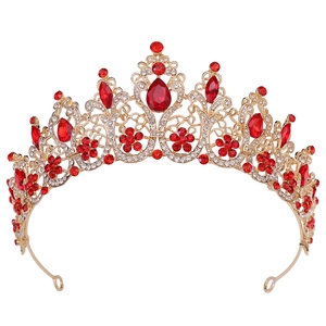 Detailed close-up of Baroque gold bridal crown with red drop-shaped crystals and floral patterns