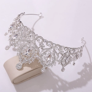 Gros plan d'une couronne de mariée avec motifs ciselés en argent et cristaux