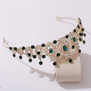 Detail of gold bridal crown featuring white rhinestones and green teardrop gemstones