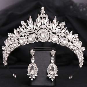 Detail view of Baroque crystal bridal crown and matching teardrop earrings on black fabric
