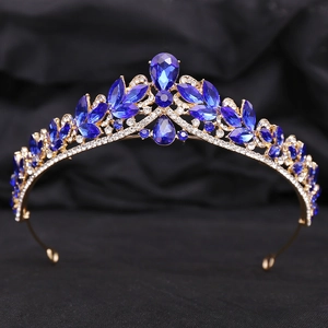 Detailed close-up of a royal gold crown with deep blue crystals and shimmering rhinestones