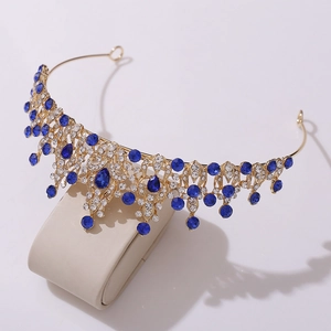 Close-up of golden crown with blue crystals and white rhinestones for bridal hairstyle