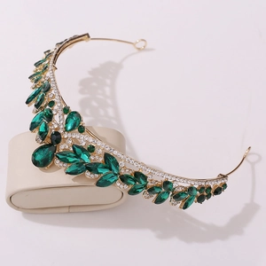 Detail of bridal tiara featuring emerald green crystals on a gold alloy frame