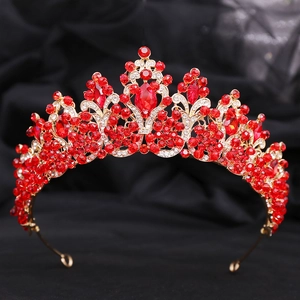 Detail showing red faceted crystals and golden vine textures on the bridal crown