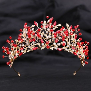 Detailed view of intricate gold leaf metalwork with red crystal beads for bridal crown
