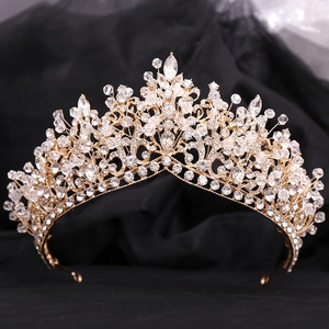 Detail of gold bridal crown with handset rhinestones on a textured black tulle background