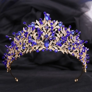 Détail d'une couronne de mariée dorée avec cristaux bleu foncé et motifs de feuilles
