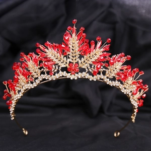 Détail d'une couronne de mariée de luxe avec cristaux rouges et feuilles dorées
