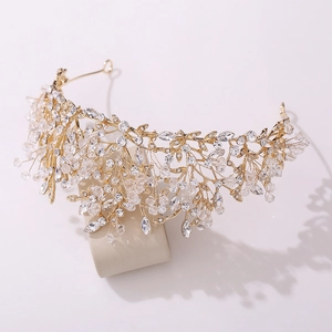 Detail of handmade bridal crown with golden leaf design and sparkling crystals